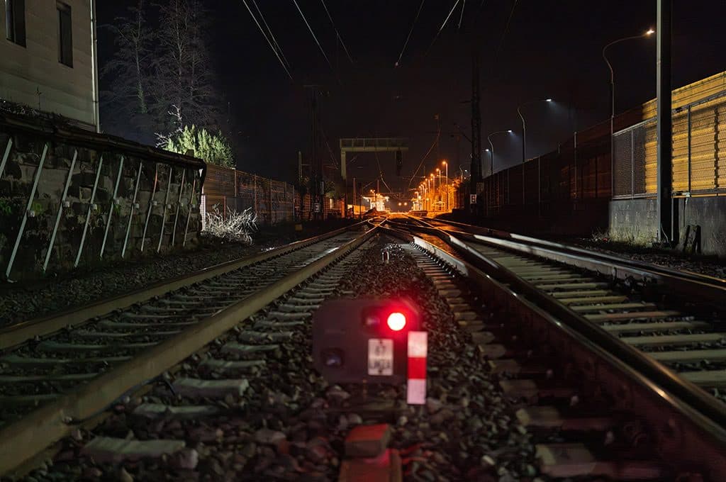 Eisenbahn bei Nacht mit Signale und Gleisen im Dunkeln.
