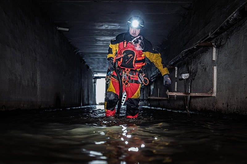 Einsatz im Kanal mit Schutzausrüstung und Stirnlampe