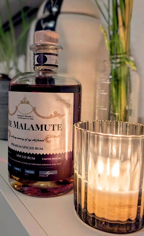 Flasche mit Spiced Rum von The Malamute, stilvoll auf einem Tresen